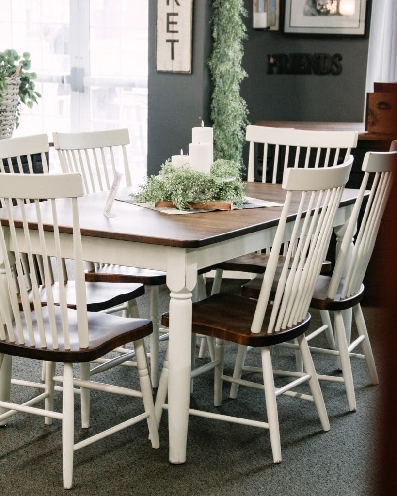 Dining room set that has a white base dining table with a brown wood top and 6 white and brown dining chairs.