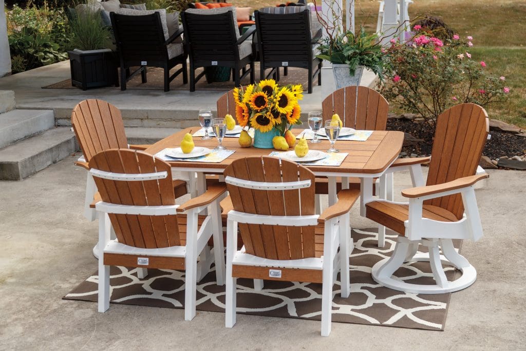 Brown and white poly furniture dining set on a back patio with a blue vase of sunflowers on the table.
