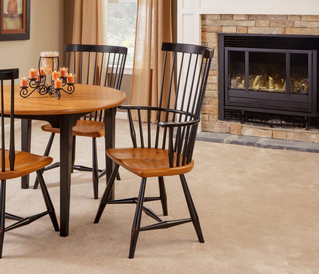 Brown and black hardwood dining set with a round dining table and 3 matching dining chairs.