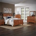 Brown stained hardwood queen bed in a room with matching dressers and a nightstand.