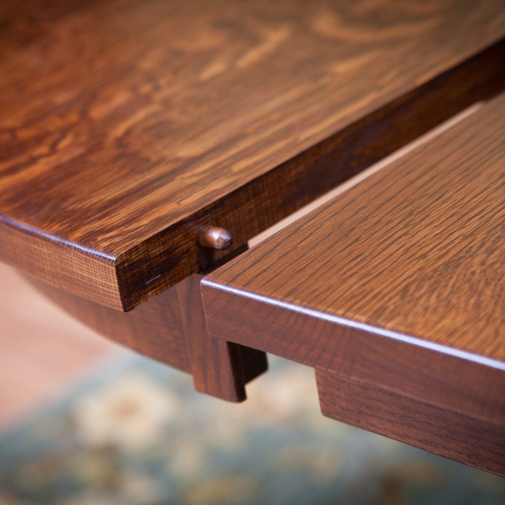 Close up of an extension table top partially open showing the wood details. 