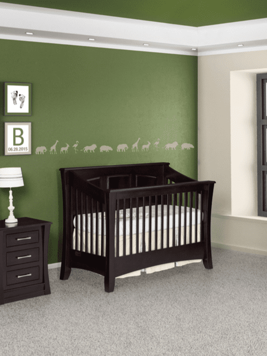 A bedroom with green walls and green ceiling and grey carpet. And a black shaker crib with a three drawer nightstand. 